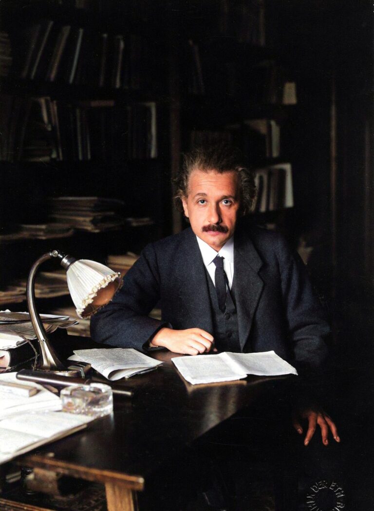 Albert Einstein an seinem Schreibtisch. Zitat zur Neugier.